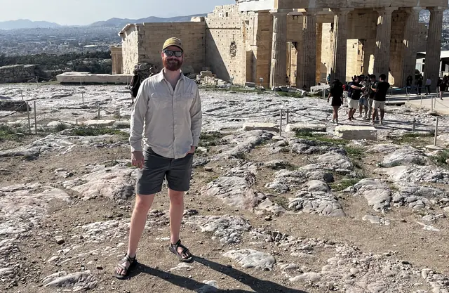 Graham Brooks standing in front of the ruins on the Acropolis in Athens